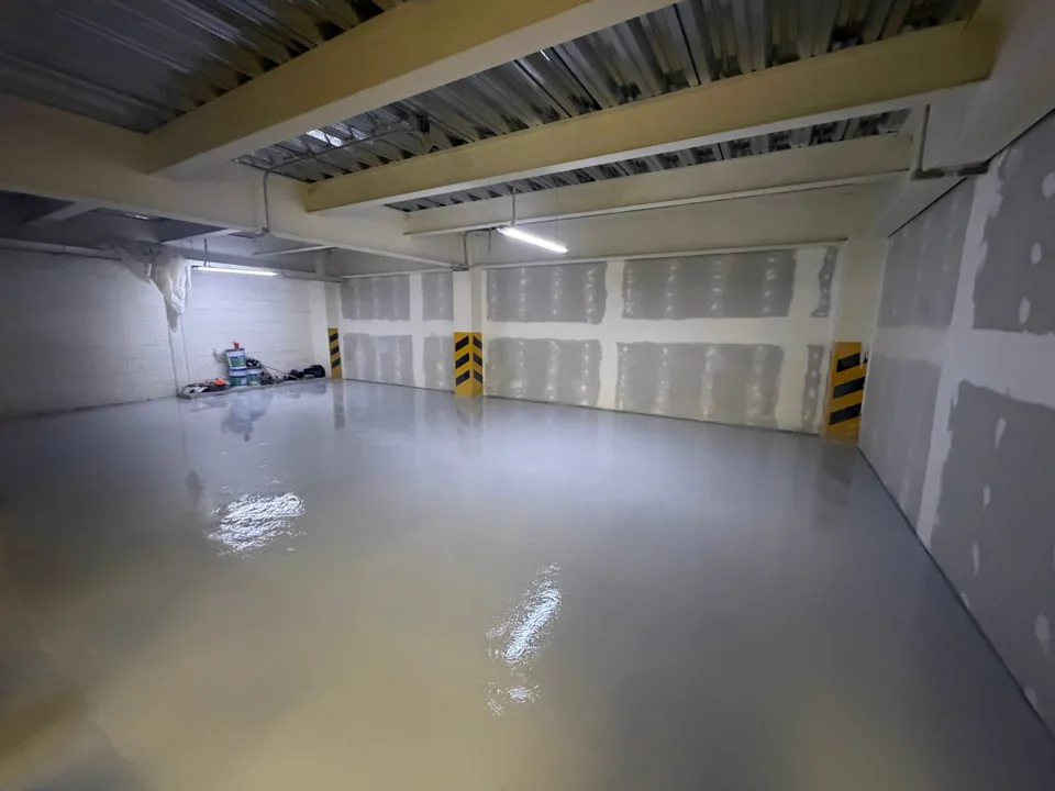 Aplicación de recubrimiento epóxico en piso de área operativa.