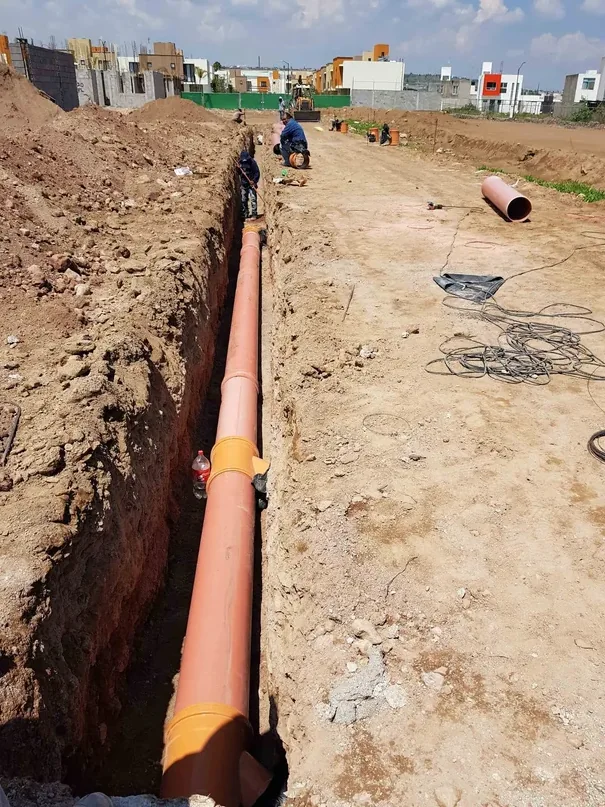 Colocación de tubería de drenaje en zanja.